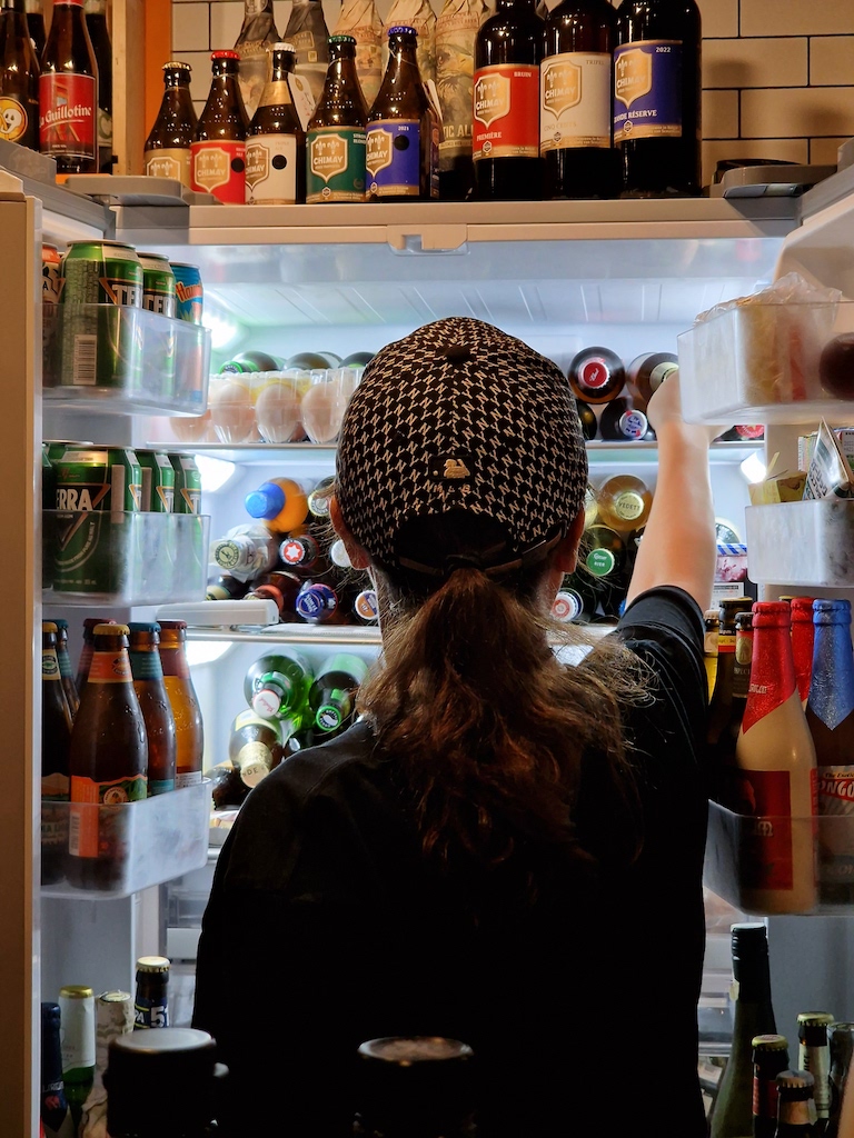 A woman in front of a refrigerator full of beers