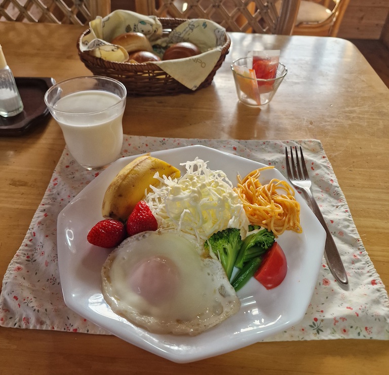 Buns, egg, fruits, and shredded cabbage for breakfast