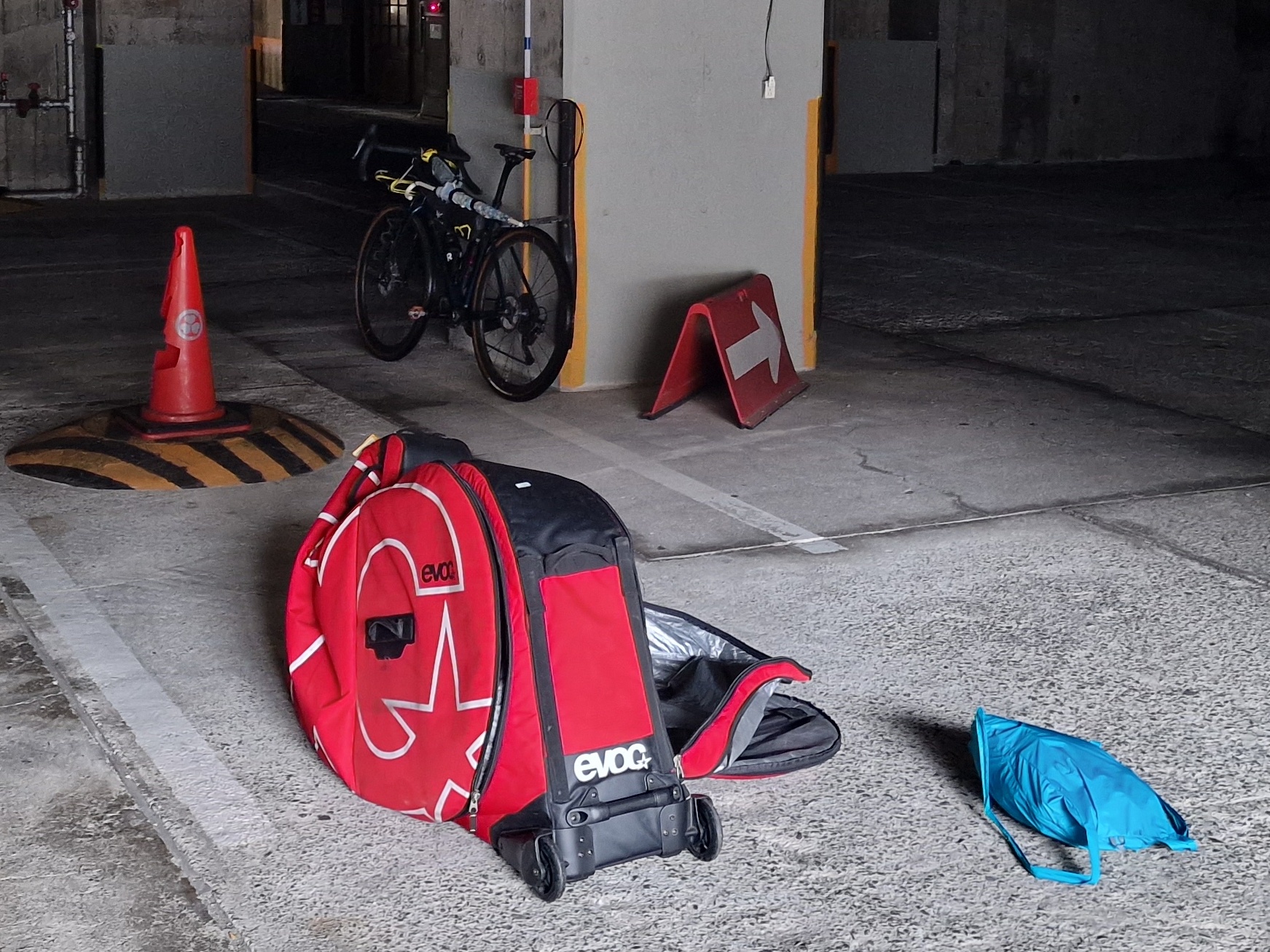 Dark parking garage with a red bike suit case