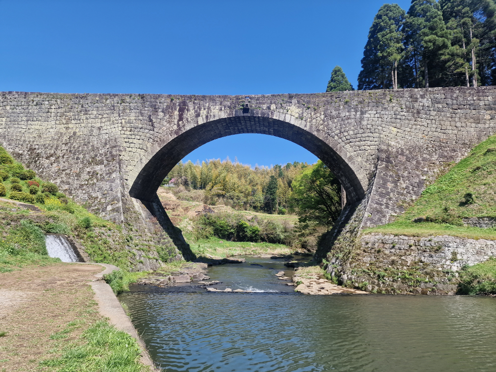 A huge stone bridge over a gentle river