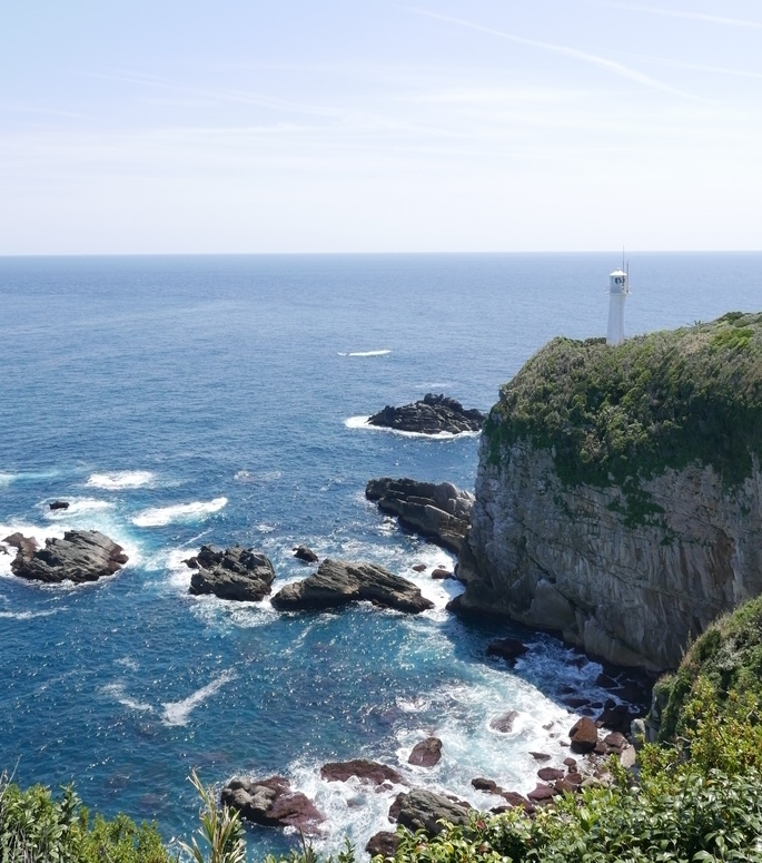 A lighthouse on a cliff edge, watching over the sea