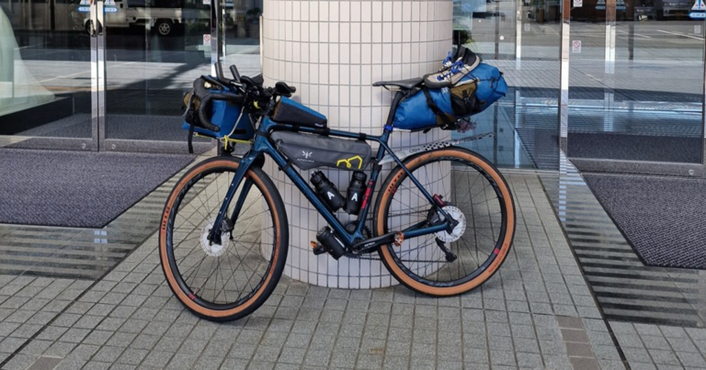 A packed gravel bike leaning against a column