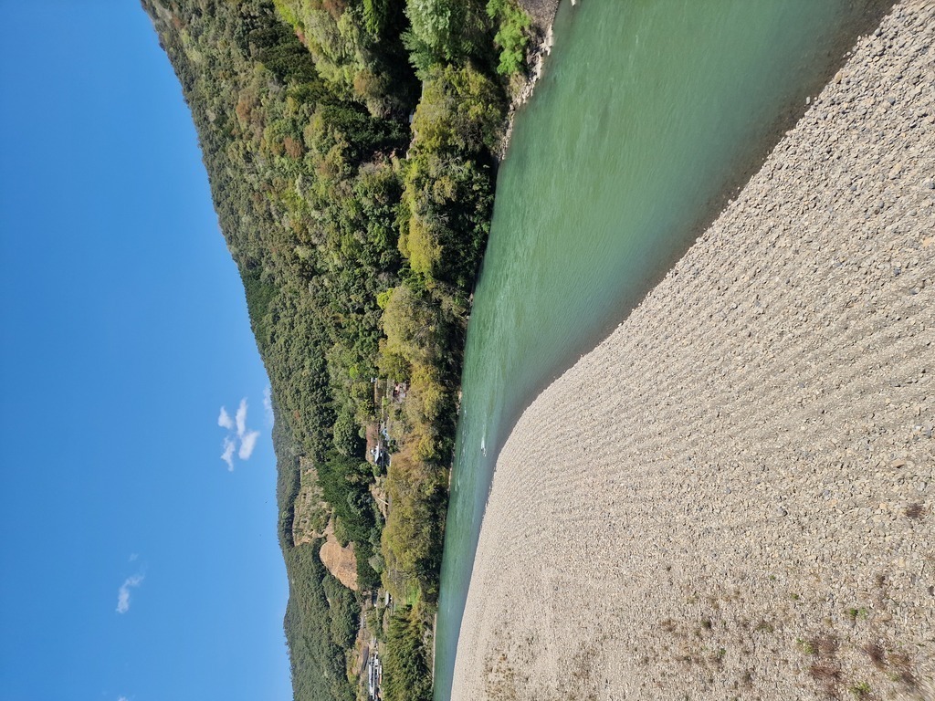 Big riverbed, with a bigger river next to it, the water has a strong green color to it