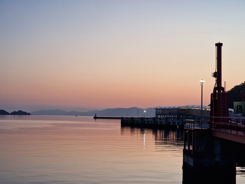 The sun setting, coloring the sea in orange and pink