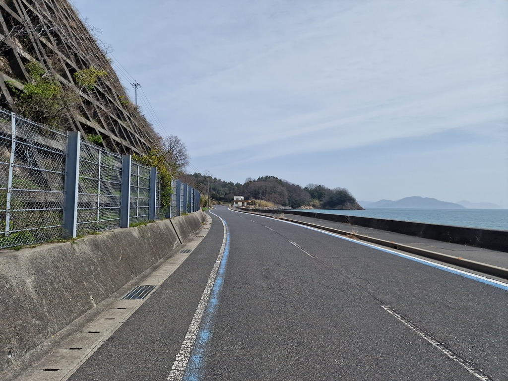 A road with two lanes, with blue line on each side of the road.