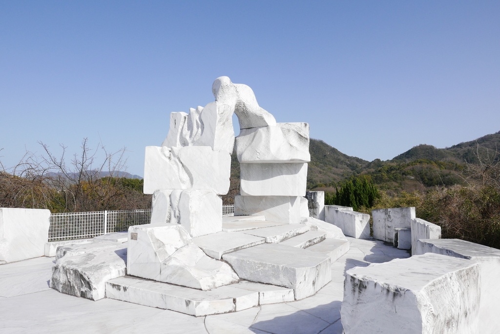 A big marble sculpture on top of a marble foot path.