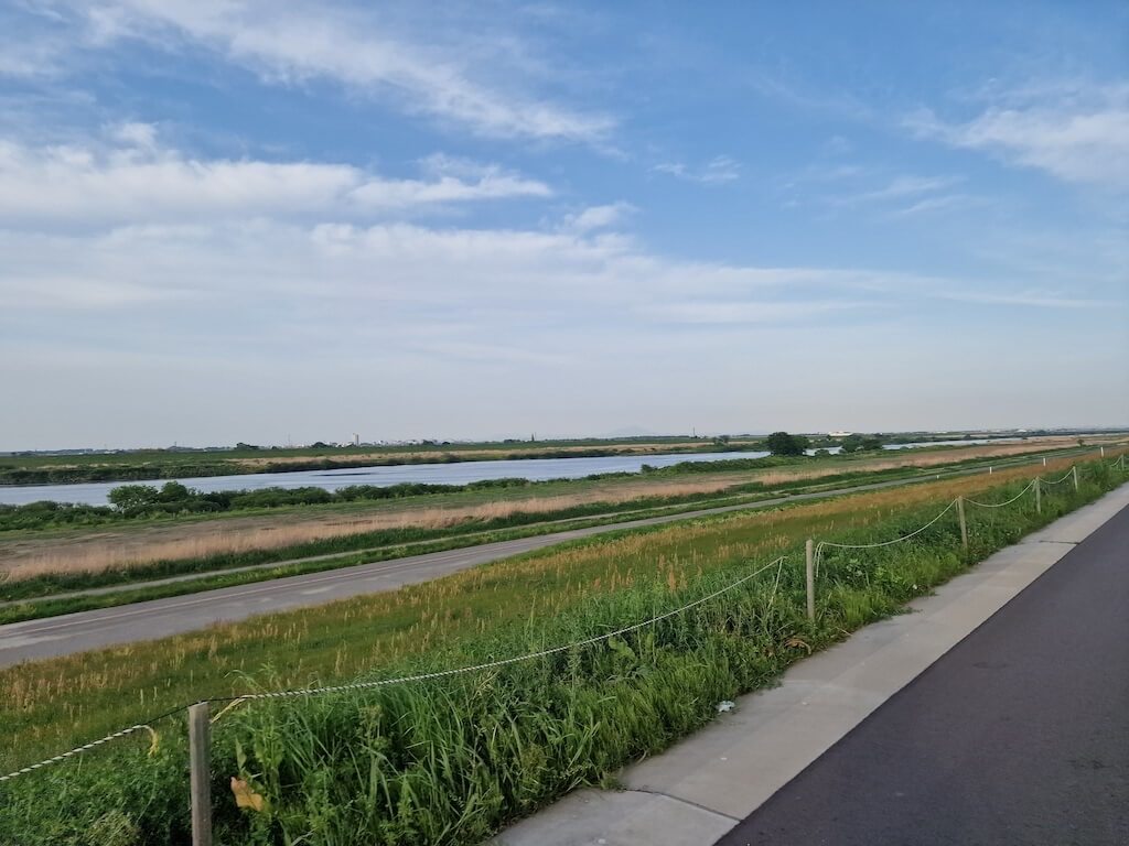 Green grass, blue river, and blue sky