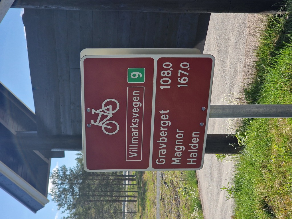 A red sign showing the distances to Gravberget, and Magnor.
